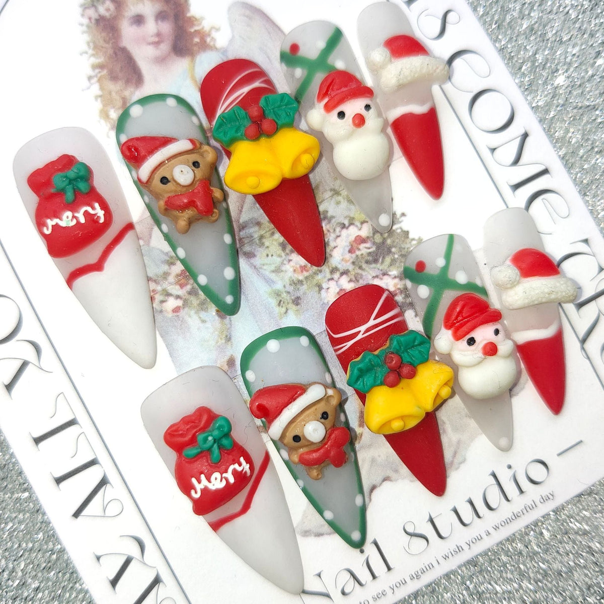 3D Christmas press-on nails with festive figures and bows on a display card - stiletto with bear and bells