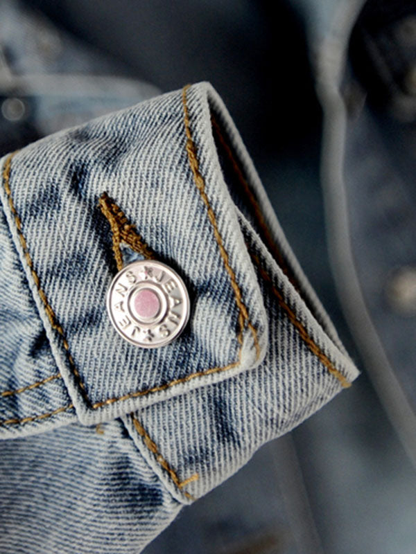 Light wash denim jacket with pearl-effect studs on the shoulders