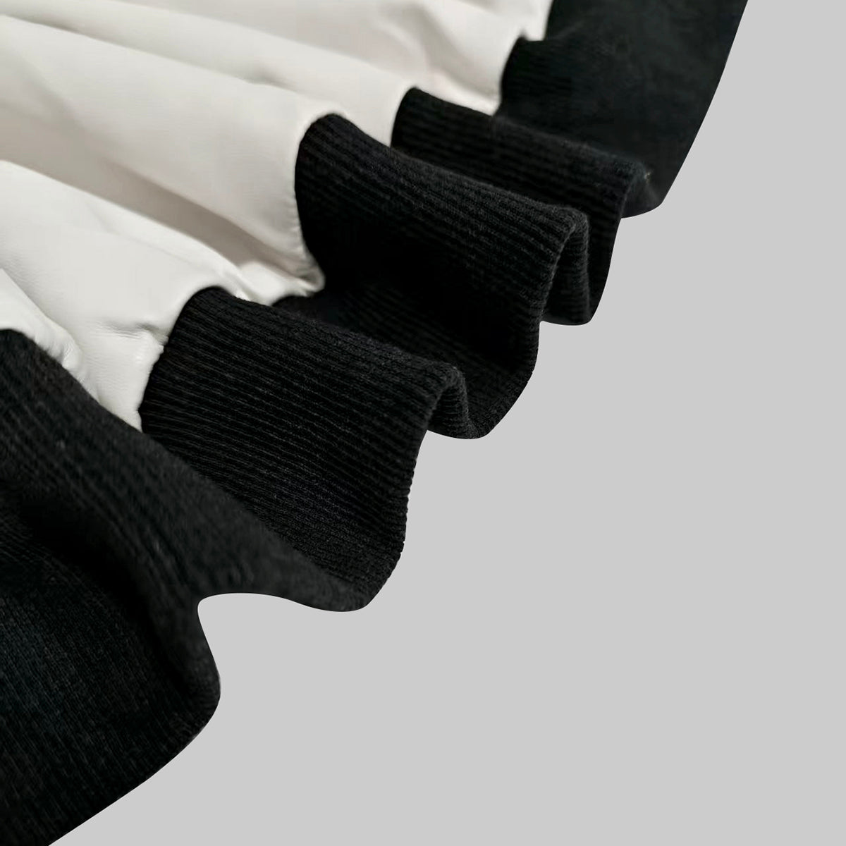 Cropped cream bomber jacket with black contrast panels and a zip front