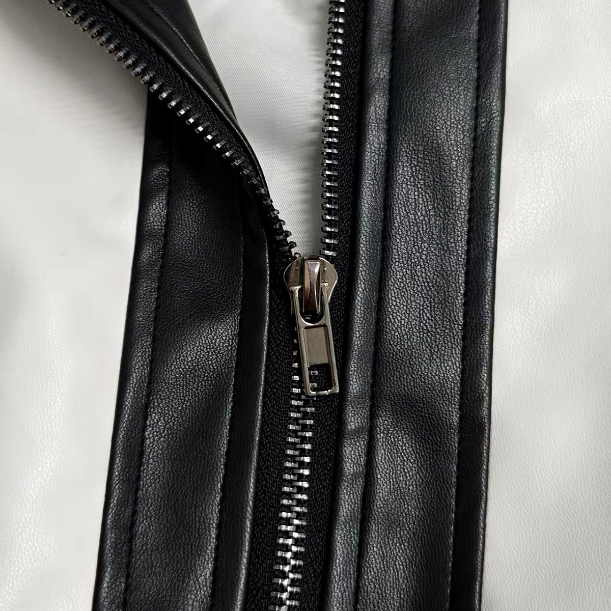 Cropped cream bomber jacket with black contrast panels and a zip front