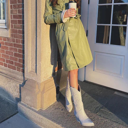 White cowboy boots styled with a green coat