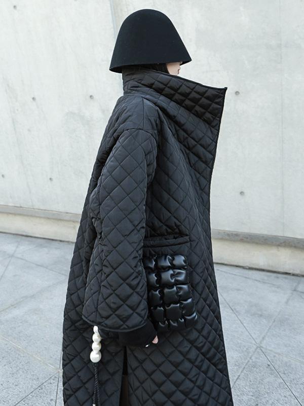 Long black quilted wrap coat with a fold-over collar and ring-buckle belt