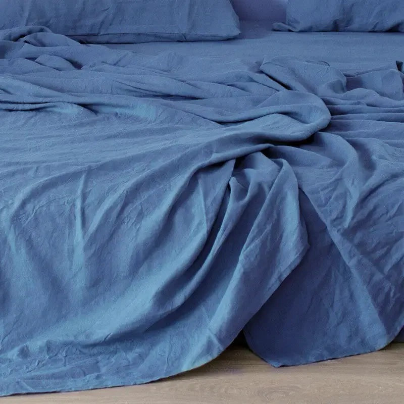 Airy woven sheet with a washed look on a bed - blue