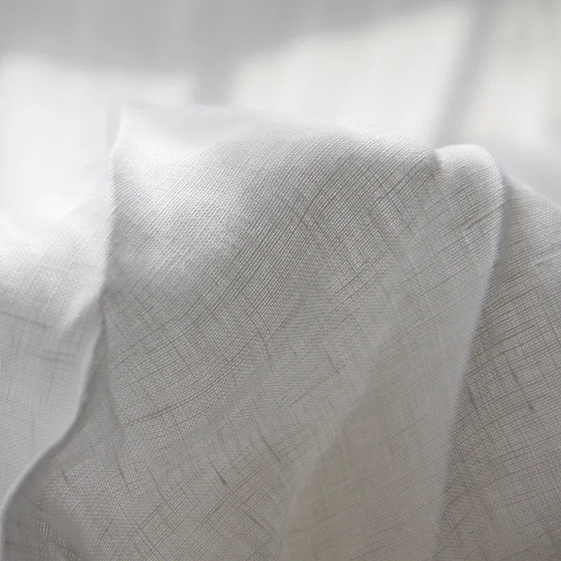 Airy woven sheet with a washed look on a bed - white