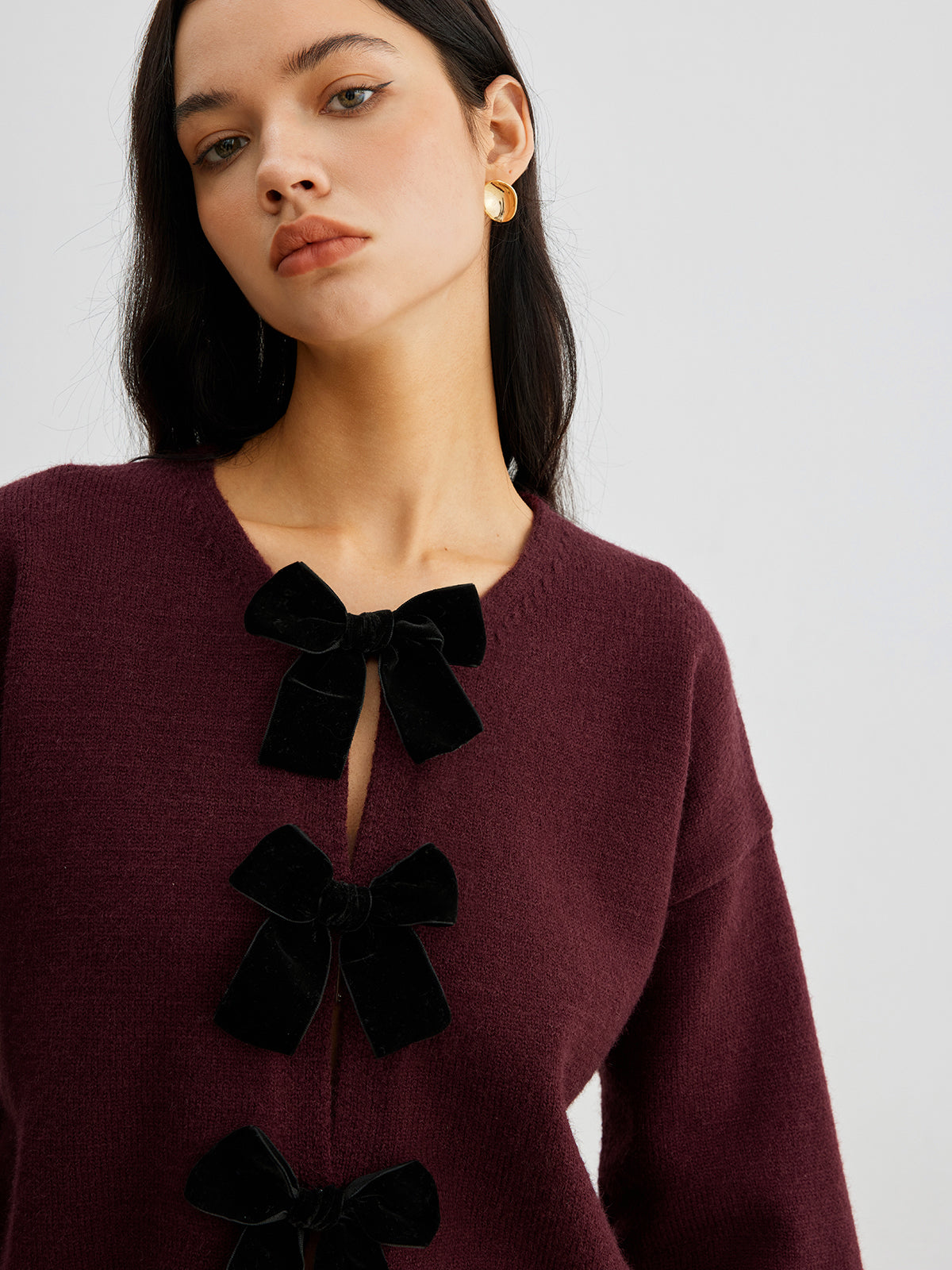 Women's short cardigan with three black bows and a crew neck