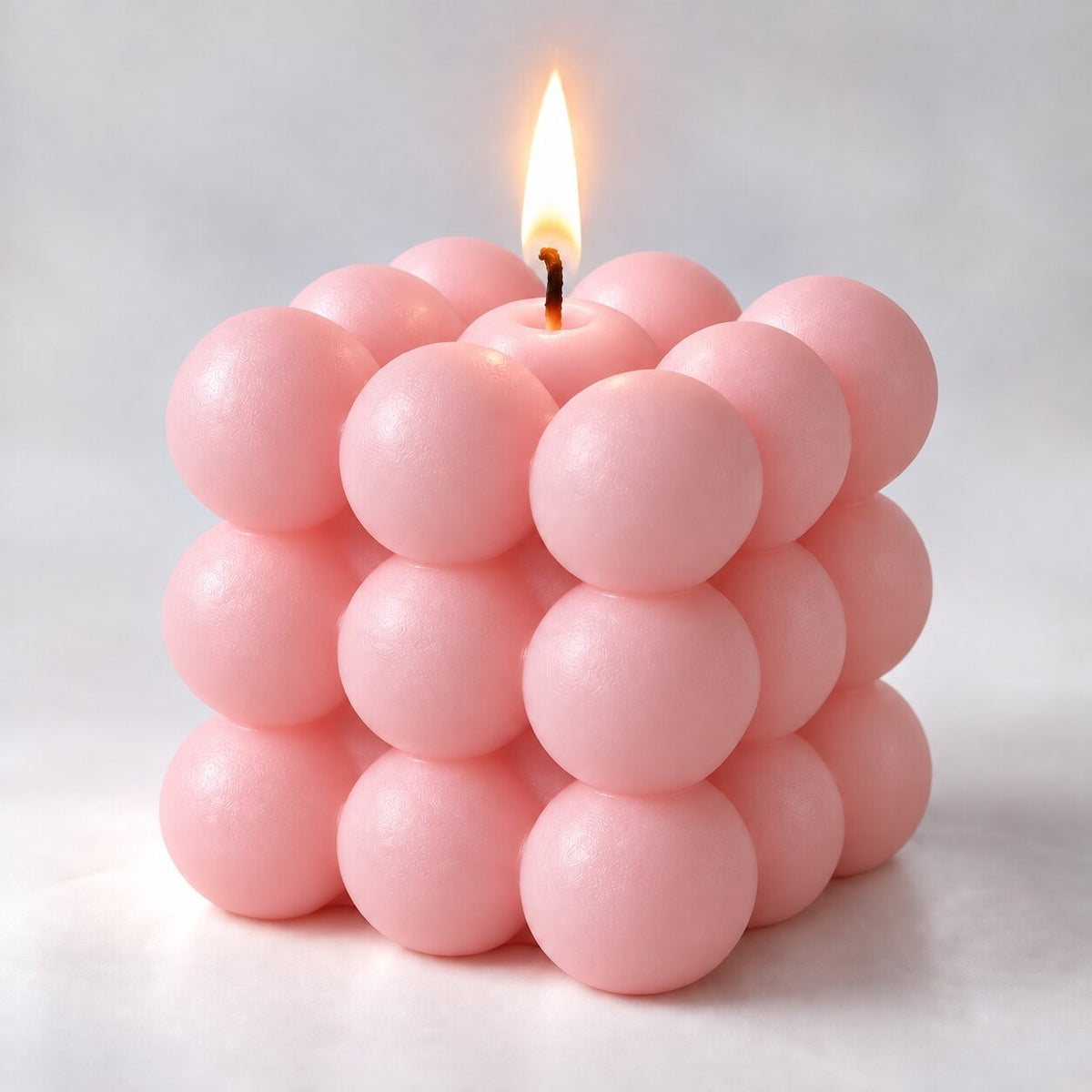 Bubble cube candle with a lit wick - pink