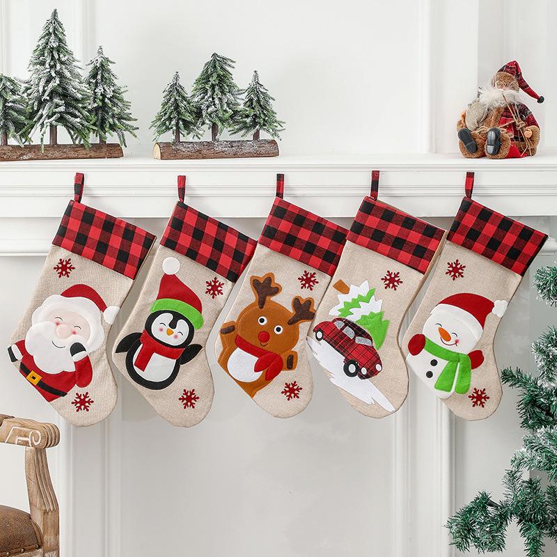 Burlap-look Christmas stocking with a red and black check cuff and a character
