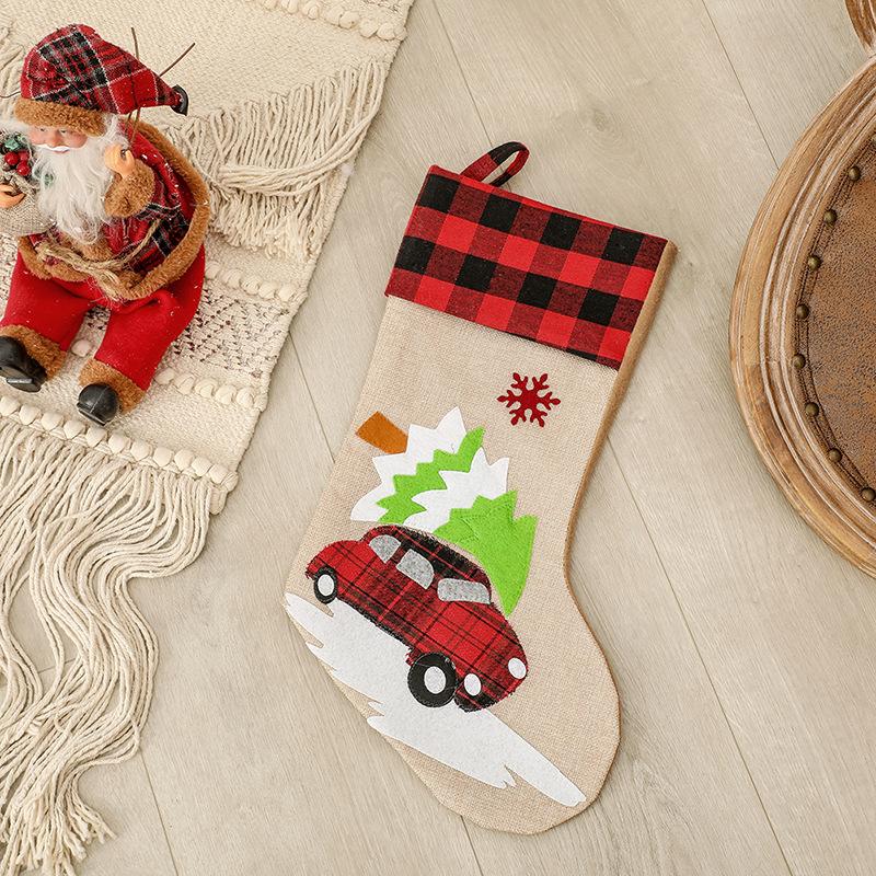 Burlap-look Christmas stocking with a red and black check cuff and a character - red car with tree
