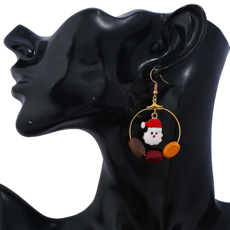 Gold-tone Christmas hoop earrings with beads and a festive charm inside the hoop