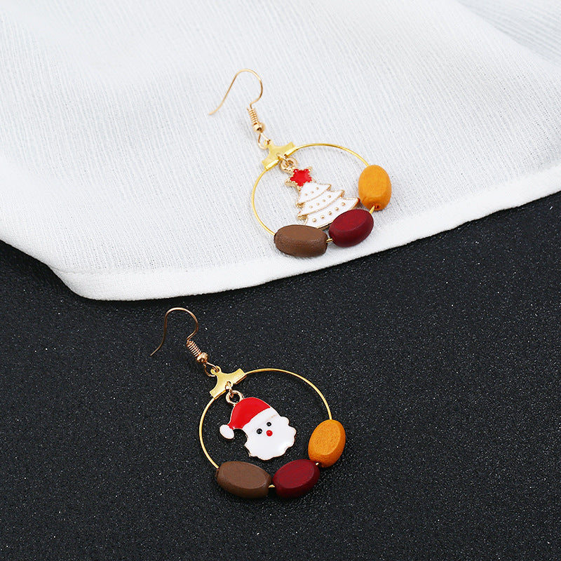 Gold-tone Christmas hoop earrings with beads and a festive charm inside the hoop