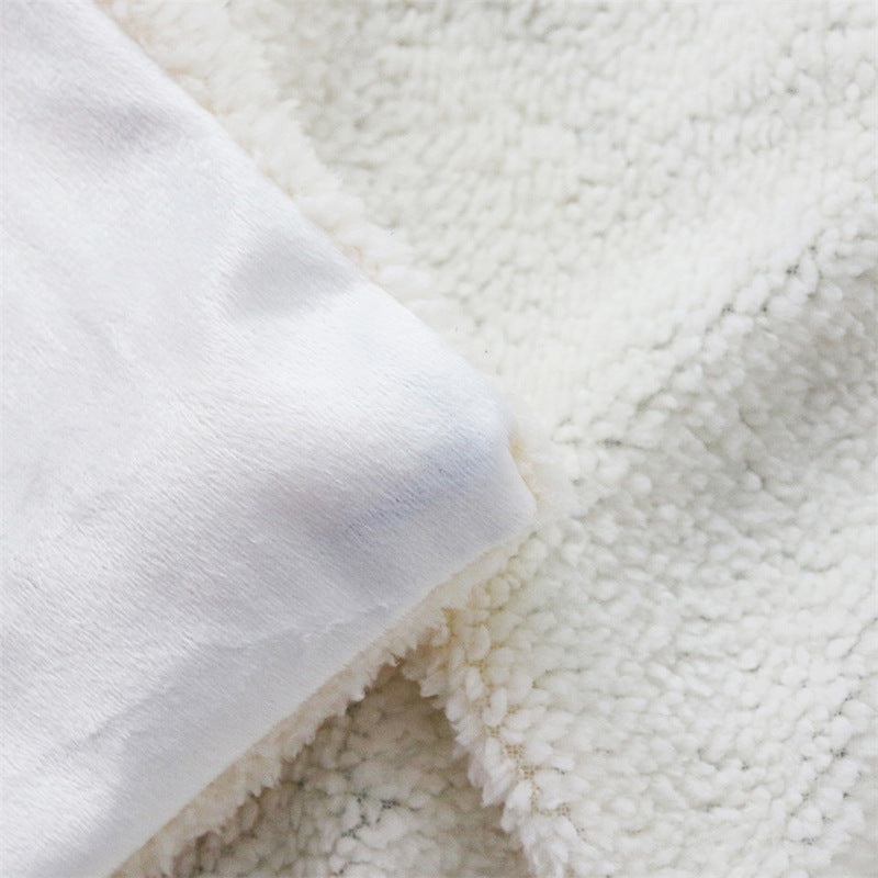 Christmas blanket with a teddy reverse and festive print, over an armchair