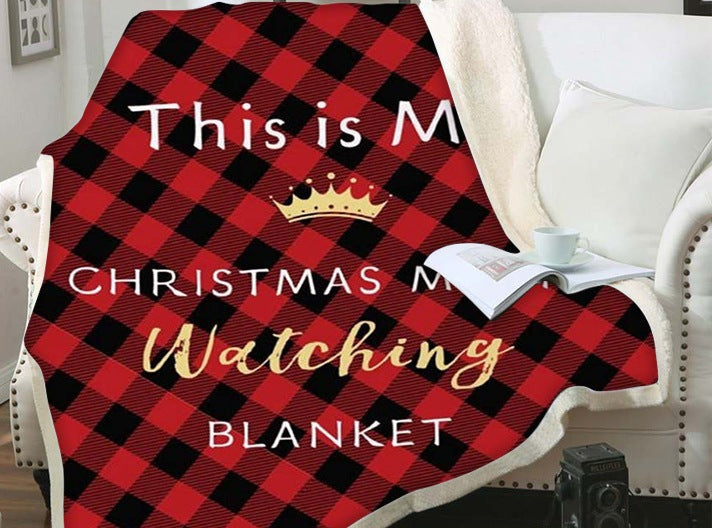 Christmas blanket with a teddy reverse and festive print, over an armchair - red check movie blanket