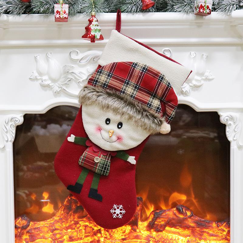 Christmas stocking with a 3D figure in a tartan hat and a white cuff by the fire - snowman on red
