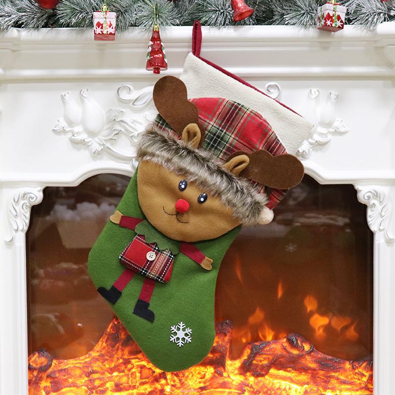 Christmas stocking with a 3D figure in a tartan hat and a white cuff by the fire - reindeer on green