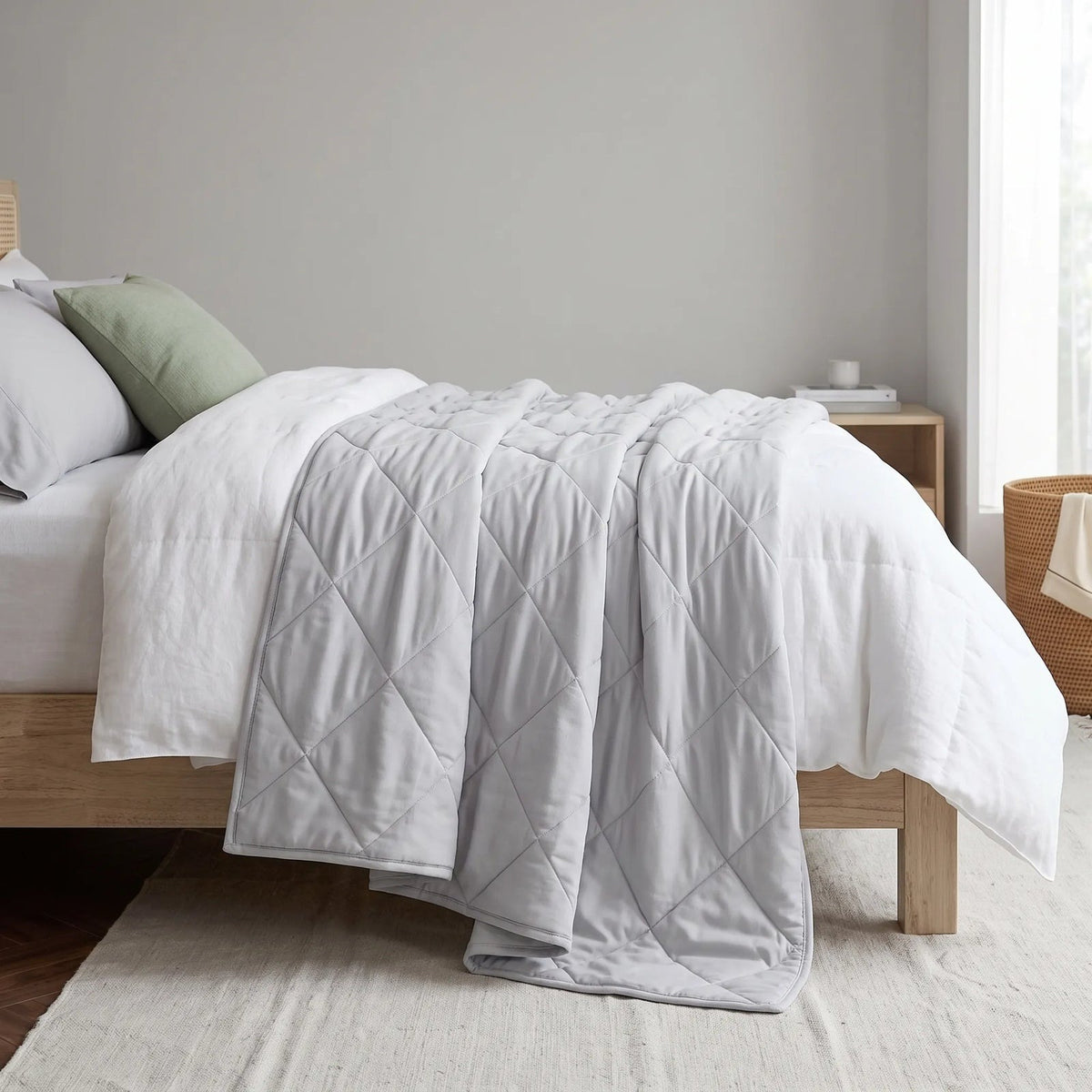 Light cooling blanket with diamond stitching over a made bed