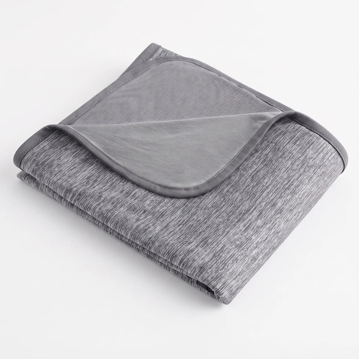 Reversible cooling blanket over a made bed - grey
