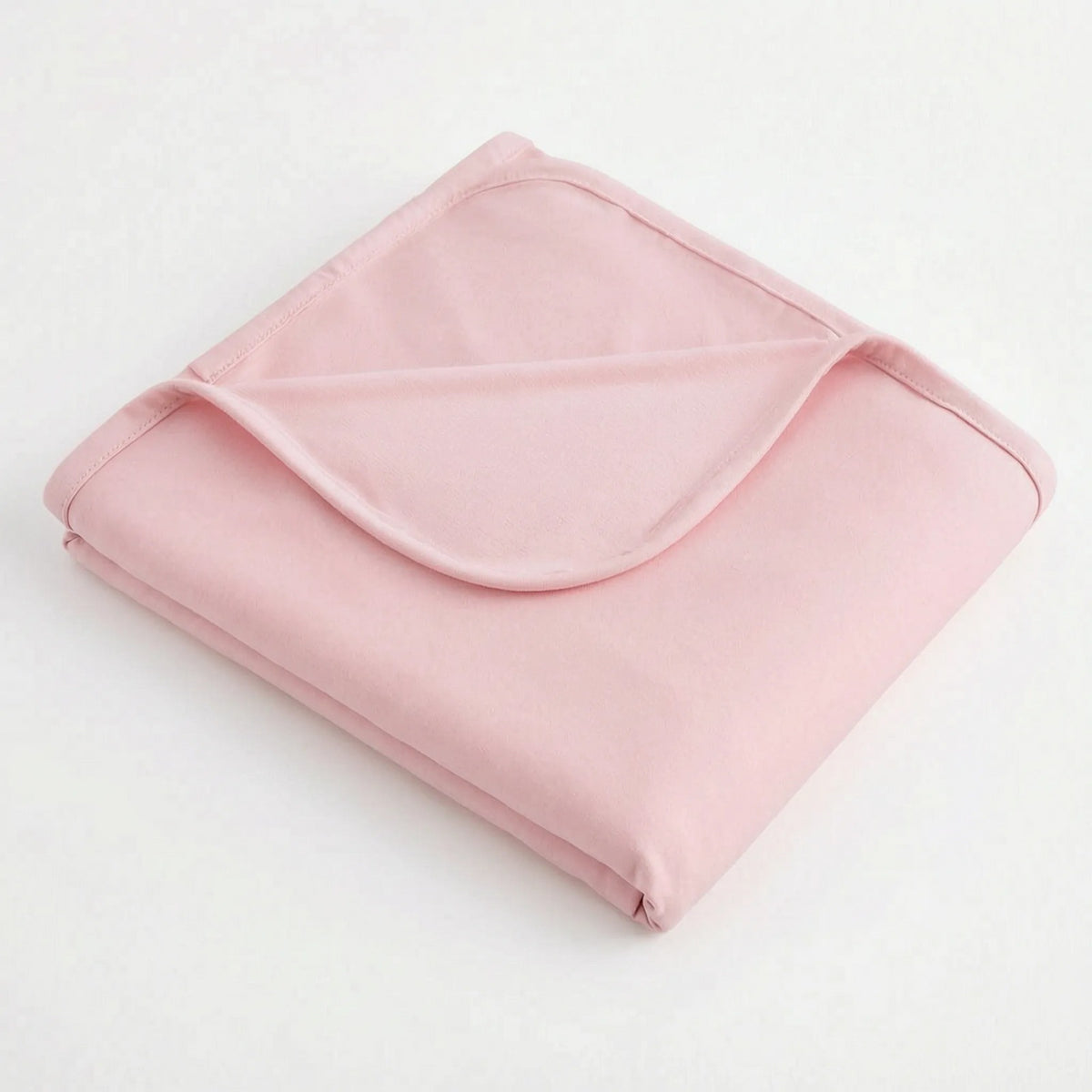 Reversible cooling blanket over a made bed - pink