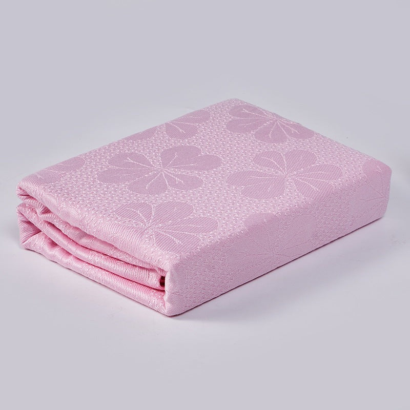 Cooling blanket with a woven floral pattern on a bed - pink