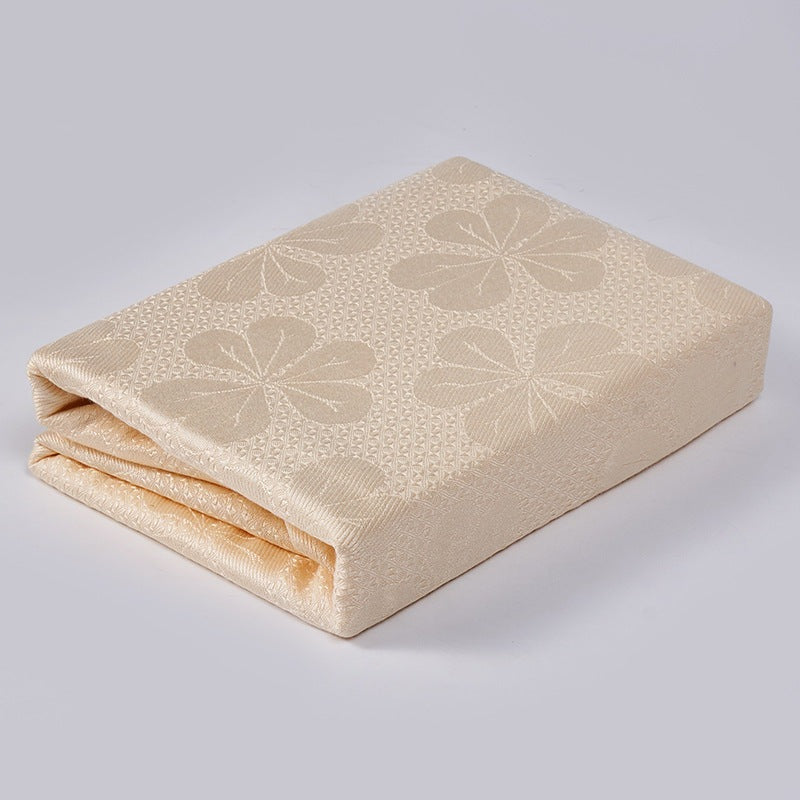 Cooling blanket with a woven floral pattern on a bed - peach