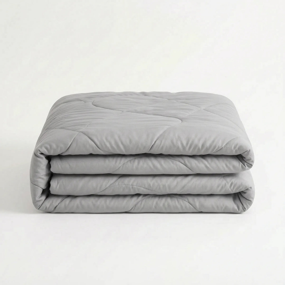 Light cooling duvet without a cover on a bed - light grey