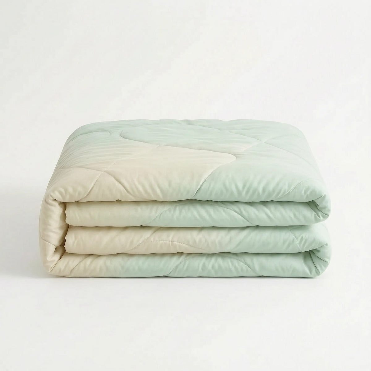Light cooling duvet without a cover on a bed - mint/cream