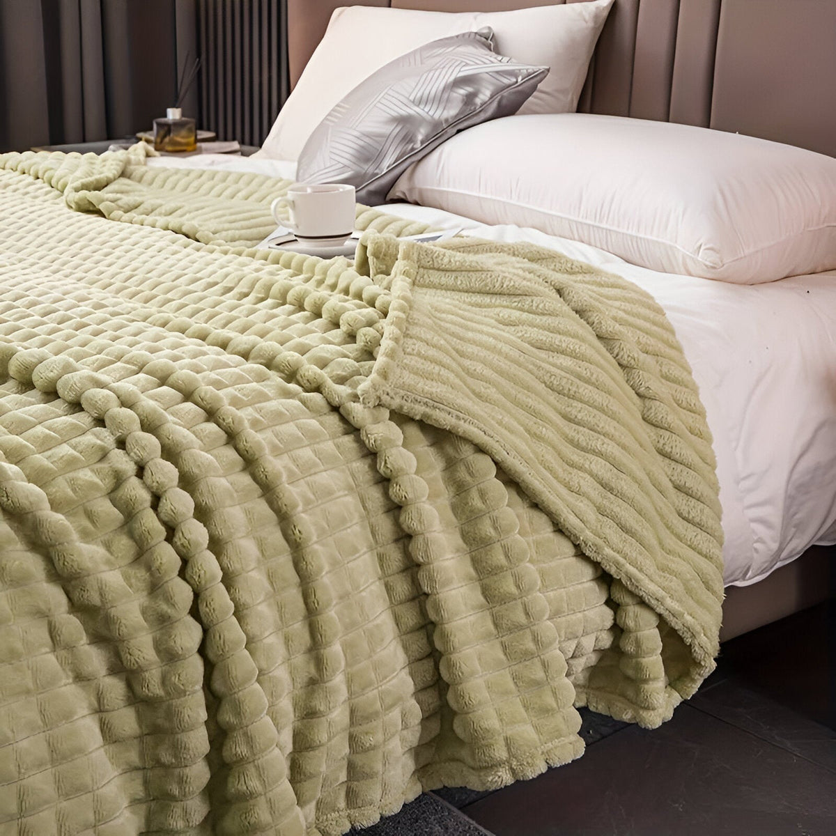 Coral fleece blanket with a square grid texture over a bed - pistachio green