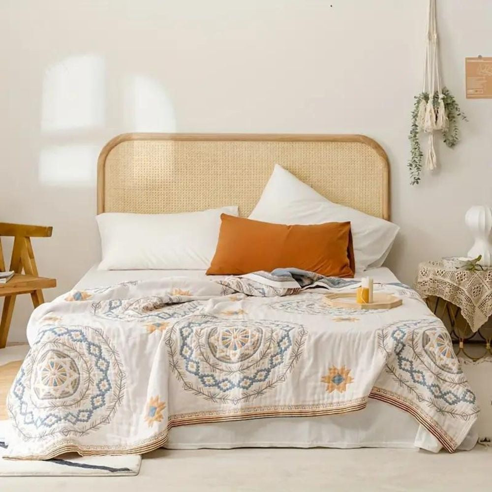 Cotton throw with a mandala print over a made bed