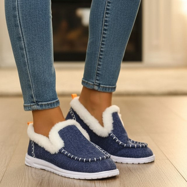 Fleece-lined slip-on shoes with a moccasin seam and a white cushioned sole in denim blue