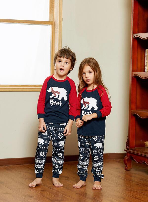 Matching family Christmas pyjamas with a polar bear print and snowflake bottoms