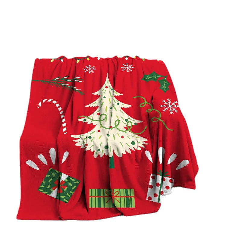 Soft fleece Christmas throw with a festive print, draped over a sofa - red white christmas tree