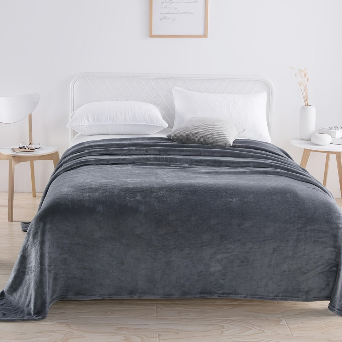 Plain flannel fleece blanket over a bed - dark grey