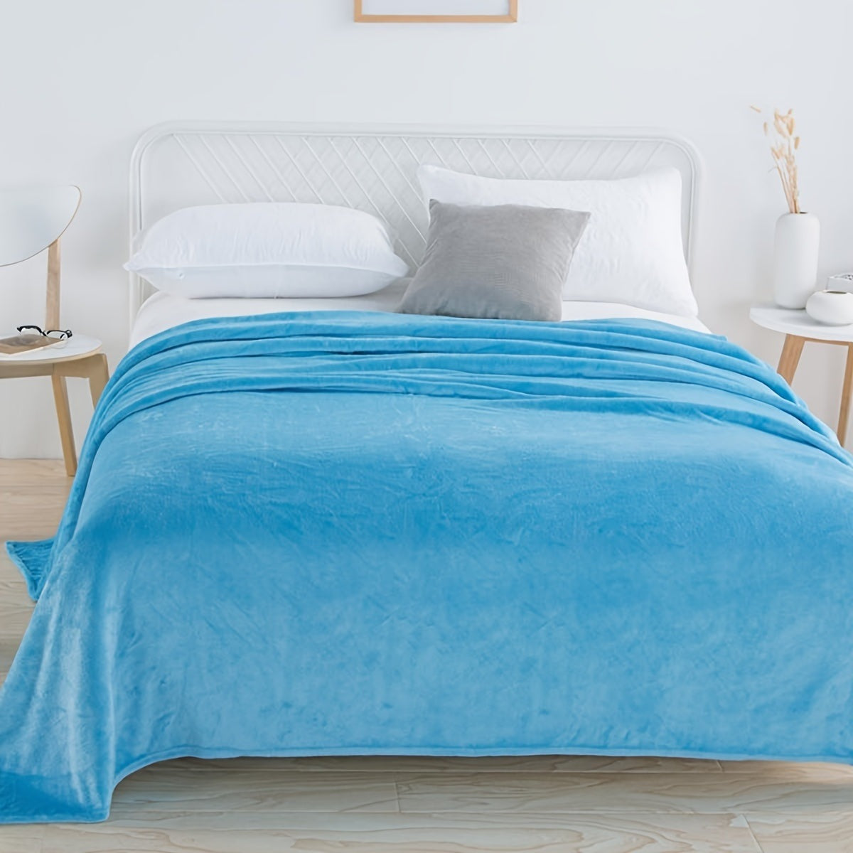 Plain flannel fleece blanket over a bed - sky blue