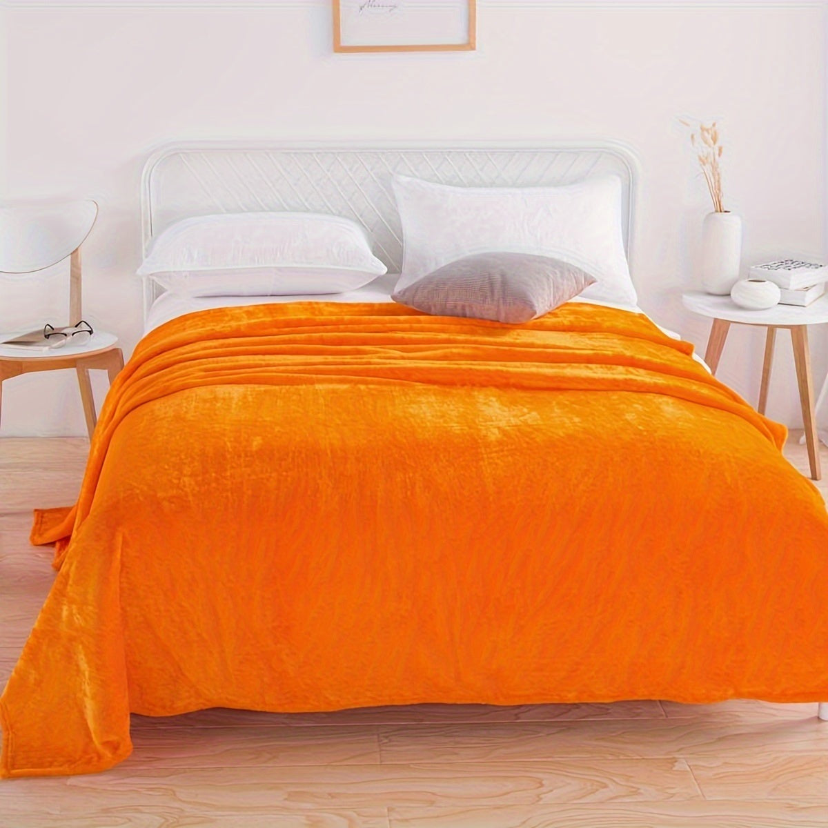 Plain flannel fleece blanket over a bed - orange