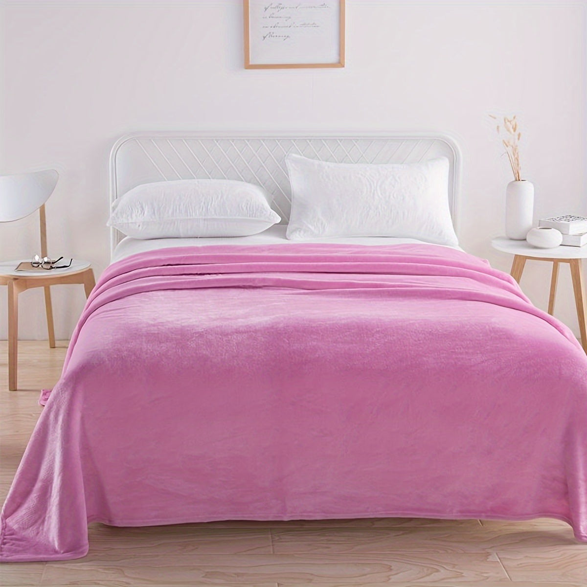 Plain flannel fleece blanket over a bed - pink