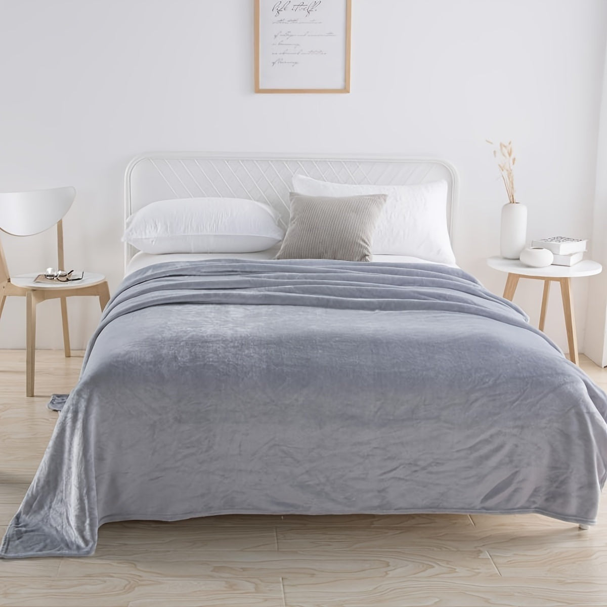 Plain flannel fleece blanket over a bed - light grey