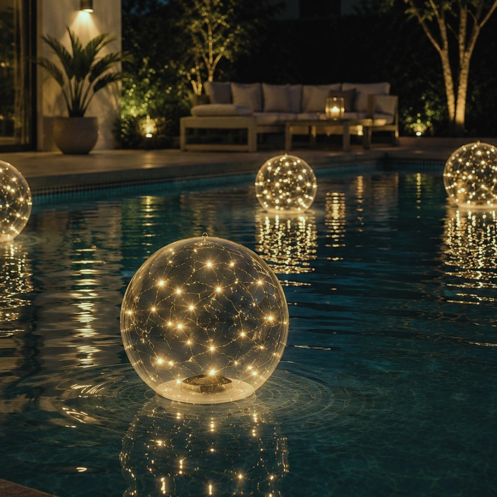 Floating solar light ball glowing in a swimming pool at night - warm white