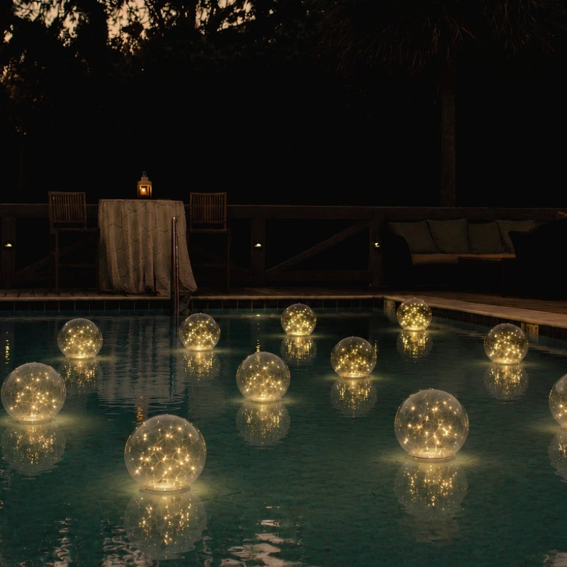 Floating solar light ball glowing in a swimming pool at night - view 5