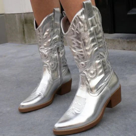 Silver metallic cowboy boots with western stitching, worn