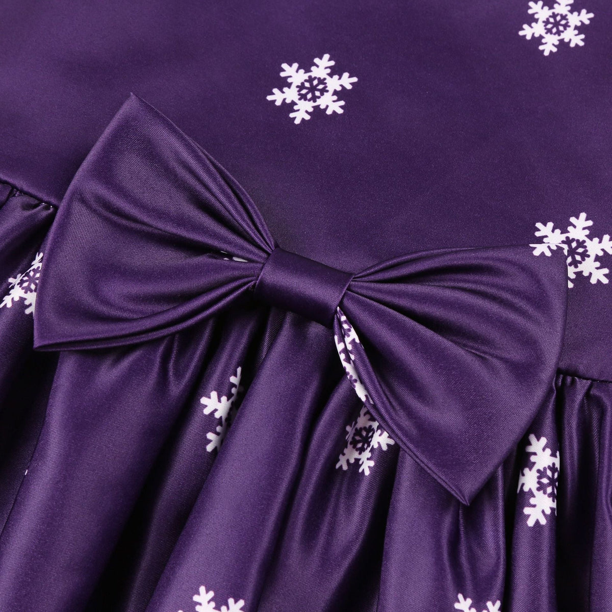 Girls' sleeveless Christmas dress with a bow and a festive print