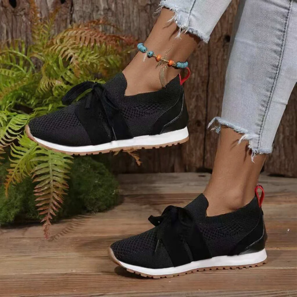 Women's knit slip-on trainers with a tied bow and a red heel tab