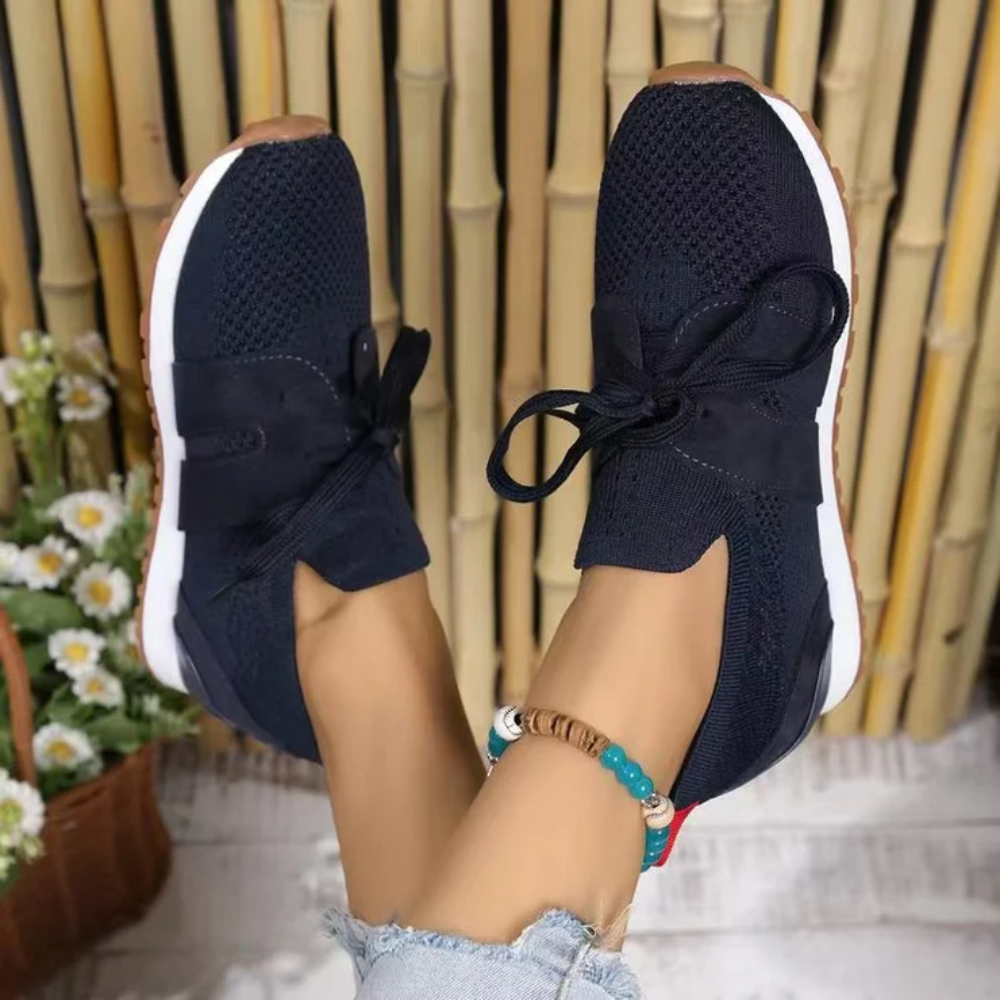 Women's knit slip-on trainers with a tied bow and a red heel tab
