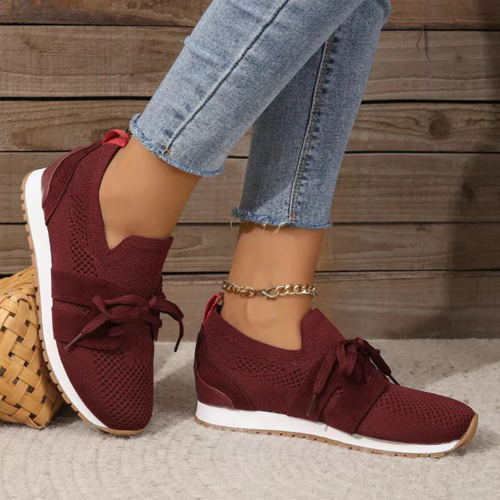 Women's knit slip-on trainers with a tied bow and a red heel tab