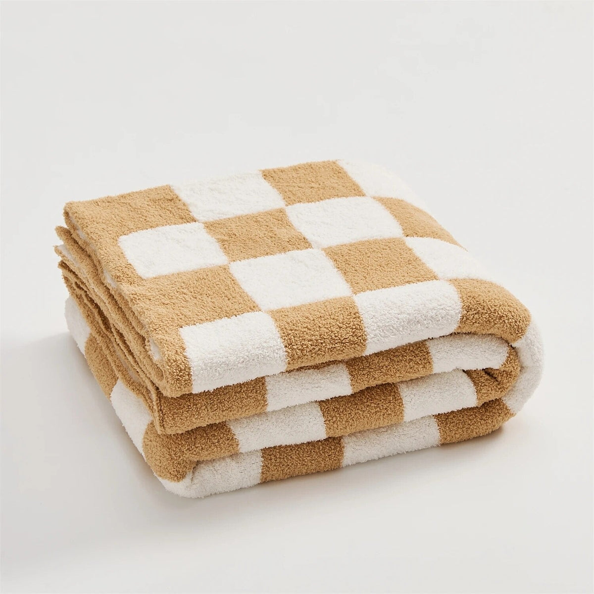 Knitted teddy throw with a checkerboard pattern over an armchair - caramel