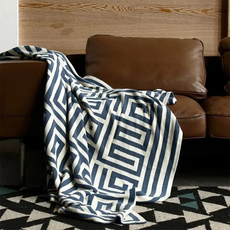 Knitted throw with a geometric pattern over a brown sofa - navy
