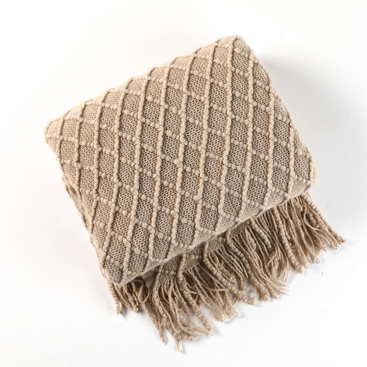 Knitted throw with a Scandinavian pattern and tassels over a chair - beige