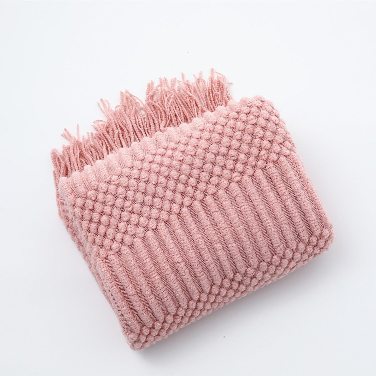 Knitted throw with a Scandinavian pattern and tassels over a chair - pink