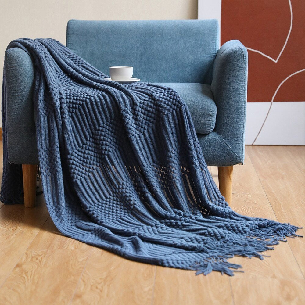 Knitted throw with a Scandinavian pattern and tassels over a chair - dark blue