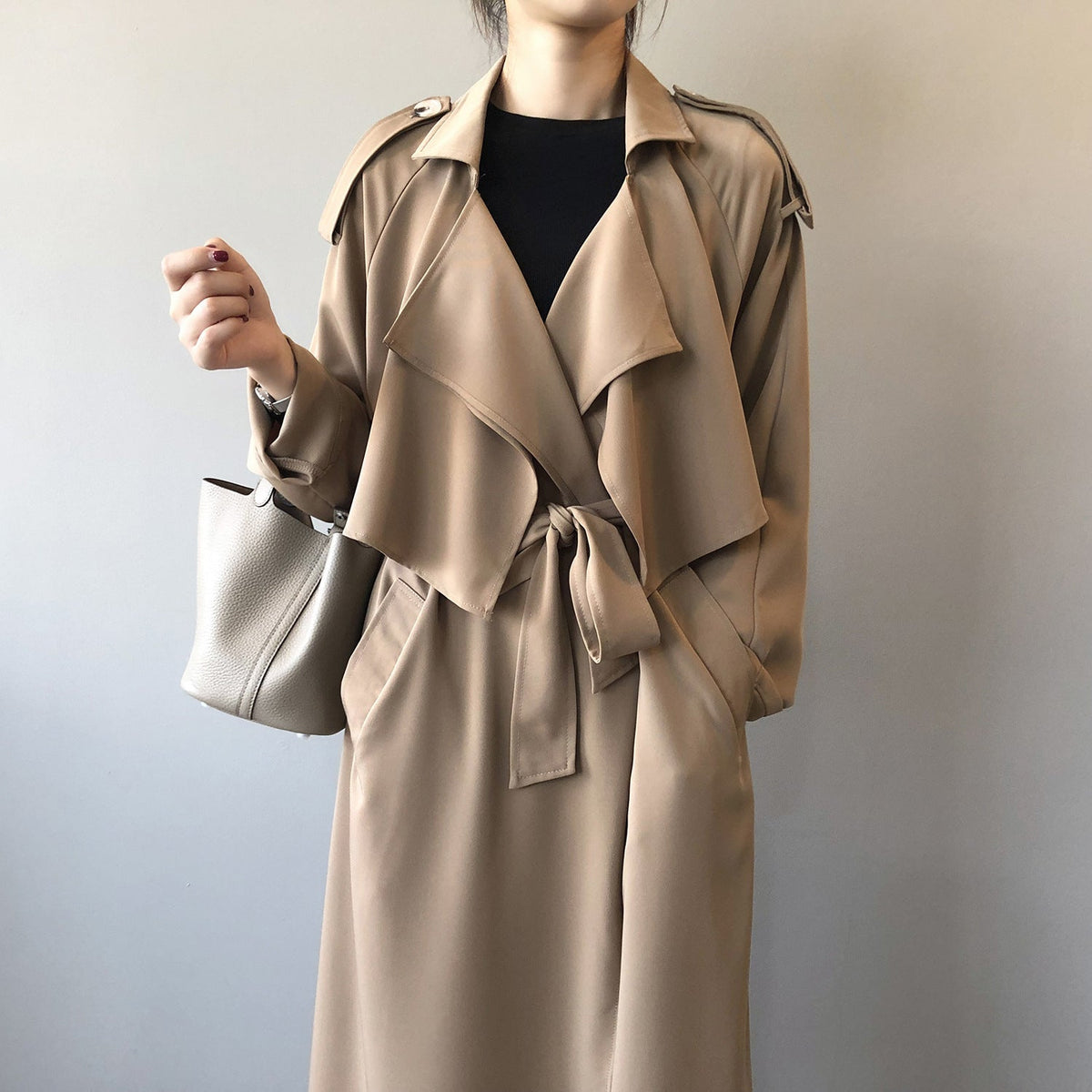Women's longline trench coat with wide draped lapels and a tie belt