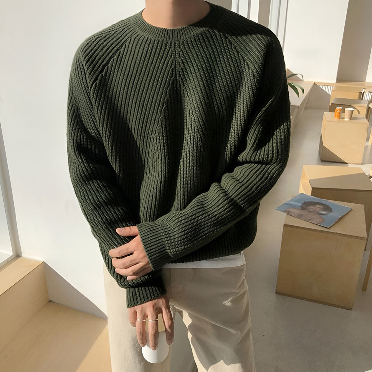 Men's ribbed jumper in green worn loose over light trousers