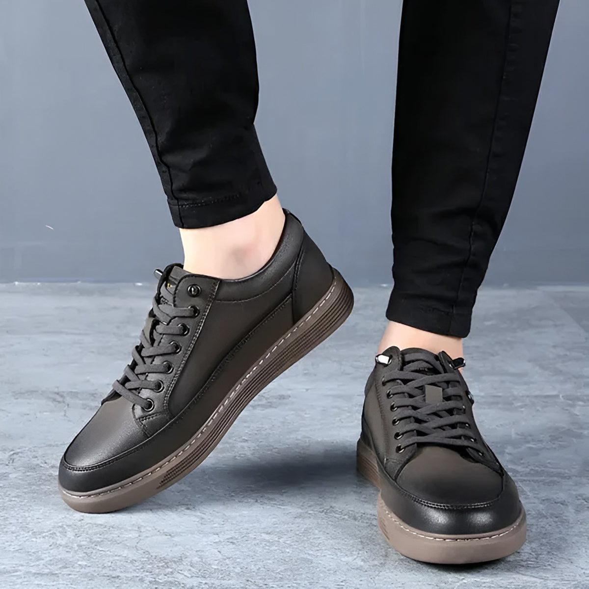 Men's smart casual trainers in dark brown, worn with black trousers